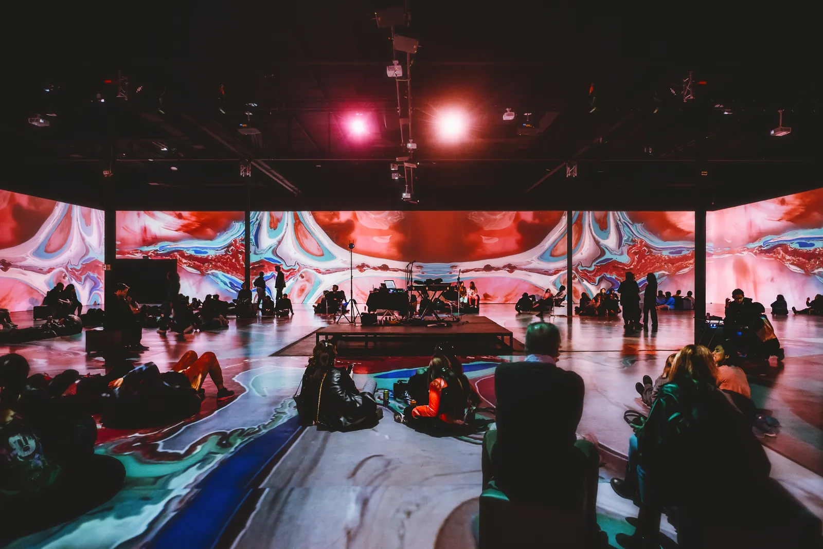 Visitors in an immersive gallery with projections on walls and floor